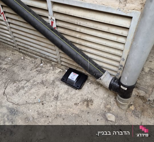 תחנת פיתיון להדברת מזיקים ליד צינור ביוב